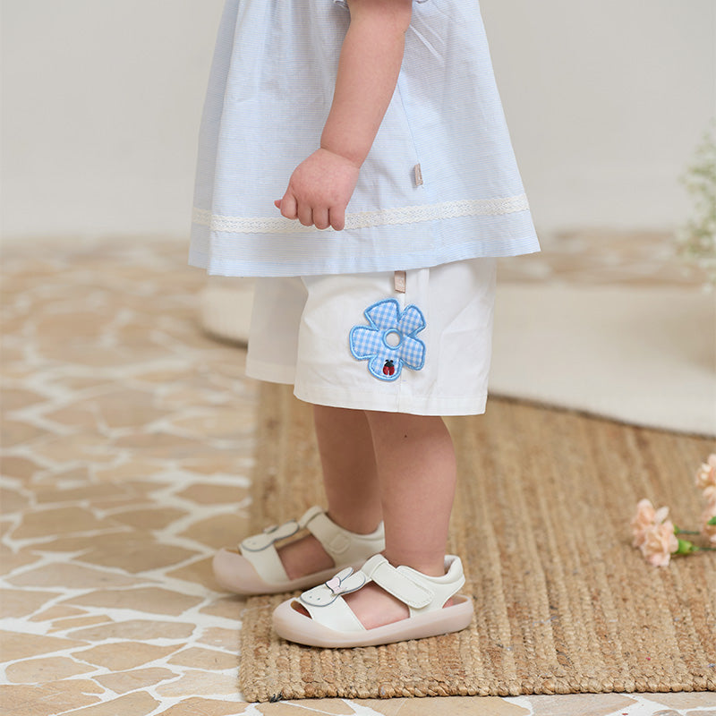 شورت صيفي أبيض للبنات الصغيرات بخصر مطاطي وتطريز زهور زرقاء وزينة زهرة كاروهات