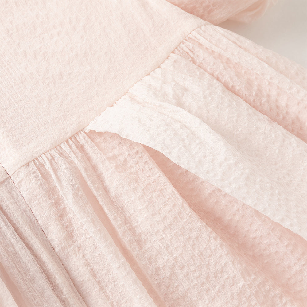 فستان بنات صيفي وردي فاتح بياقة دائرية وأكمام منفوشة من قماش محبك (ملمس بارز) بأسلوب أميرة