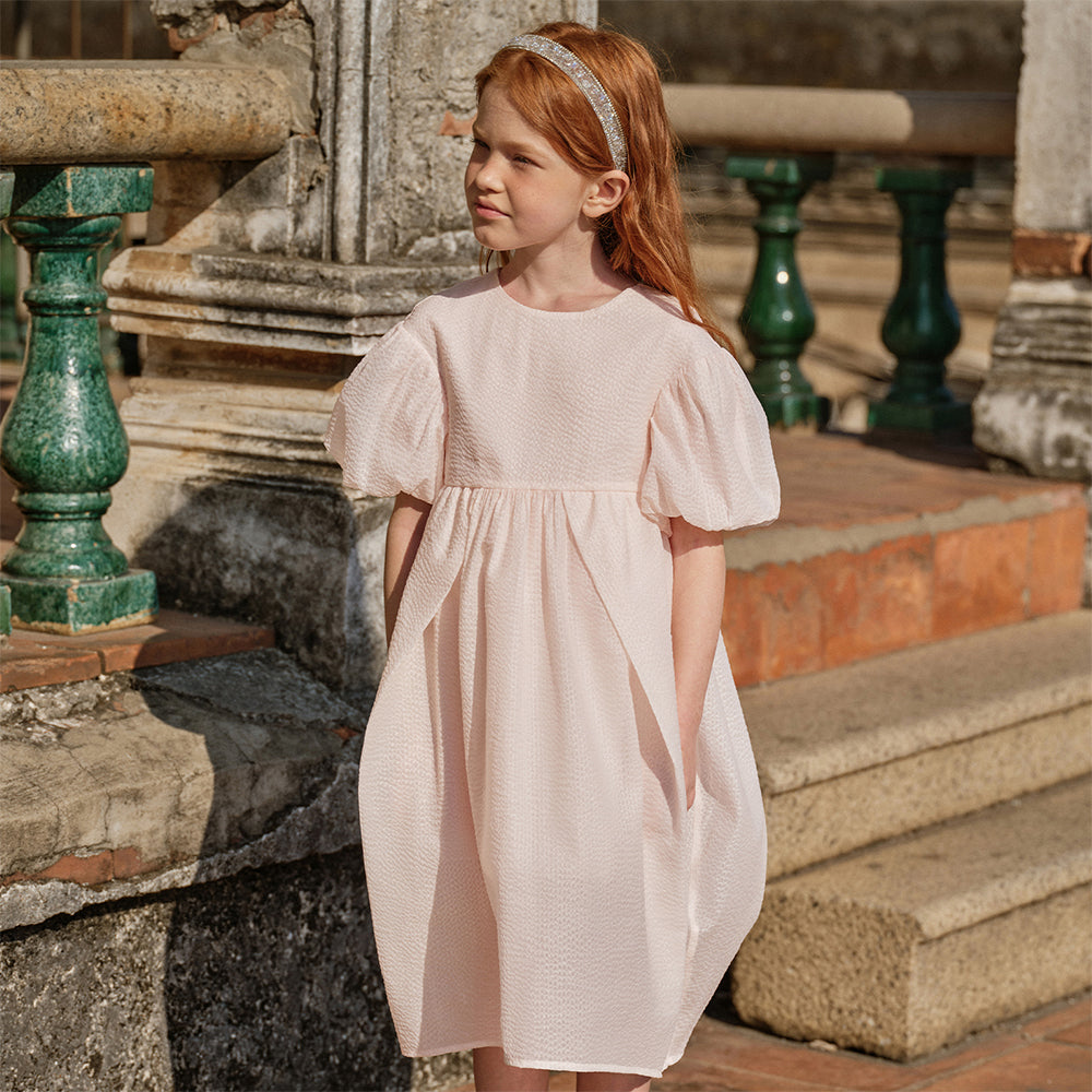 فستان بنات صيفي وردي فاتح بياقة دائرية وأكمام منفوشة من قماش محبك (ملمس بارز) بأسلوب أميرة