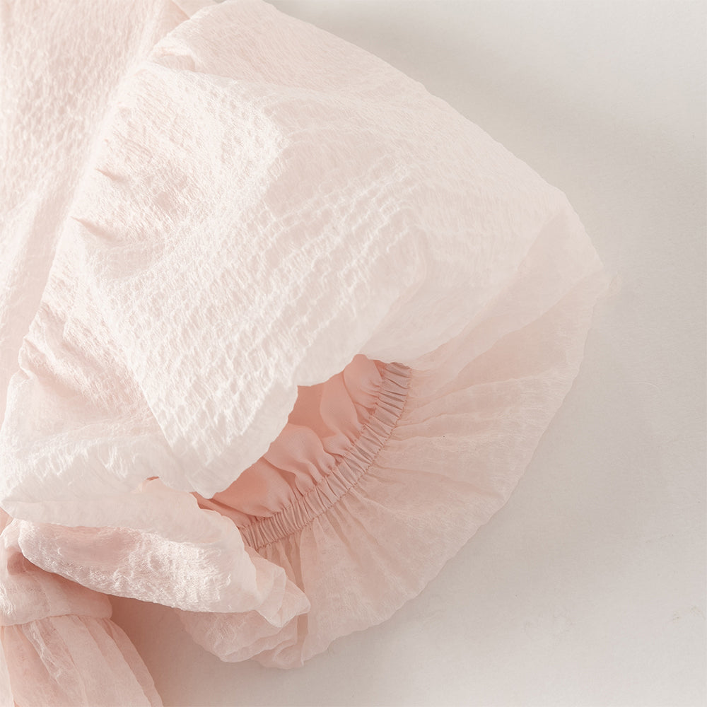 فستان بنات صيفي وردي فاتح بياقة دائرية وأكمام منفوشة من قماش محبك (ملمس بارز) بأسلوب أميرة